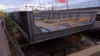 A large steel structure being transported through a city street.
