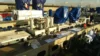 Construction materials and machinery laid out on a work platform, with blue protective covers on equipment.