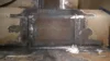 Close-up of a welded metal joint with visible markings and grinding marks on the surface.