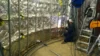 Worker welding metal frames inside a construction area with reflective insulation on the walls.