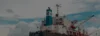 Close-up view of a ship's superstructure and cranes under a cloudy sky.