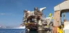 Partially constructed offshore platform at a shipyard with scaffolding and cranes.