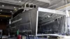 Unfinished hull of a ship under construction in a shipyard, showing the exposed framework and structure.