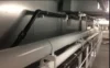 Close-up view of industrial pipes and conduits installed along a wall in a mechanical room.