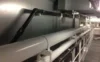 Close-up view of industrial pipes and conduits installed along a wall in a mechanical room.