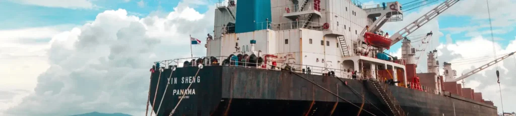 Stern view of the cargo ship 'Xin Sheng', docked at a port.