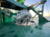 Large industrial cutter head of a dredging vessel on the deck.
