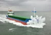 Cargo ship navigating through rough seas with waves crashing.