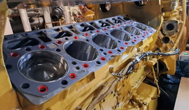 Close-up of a large engine block with exposed cylinders, showcasing the internal components.