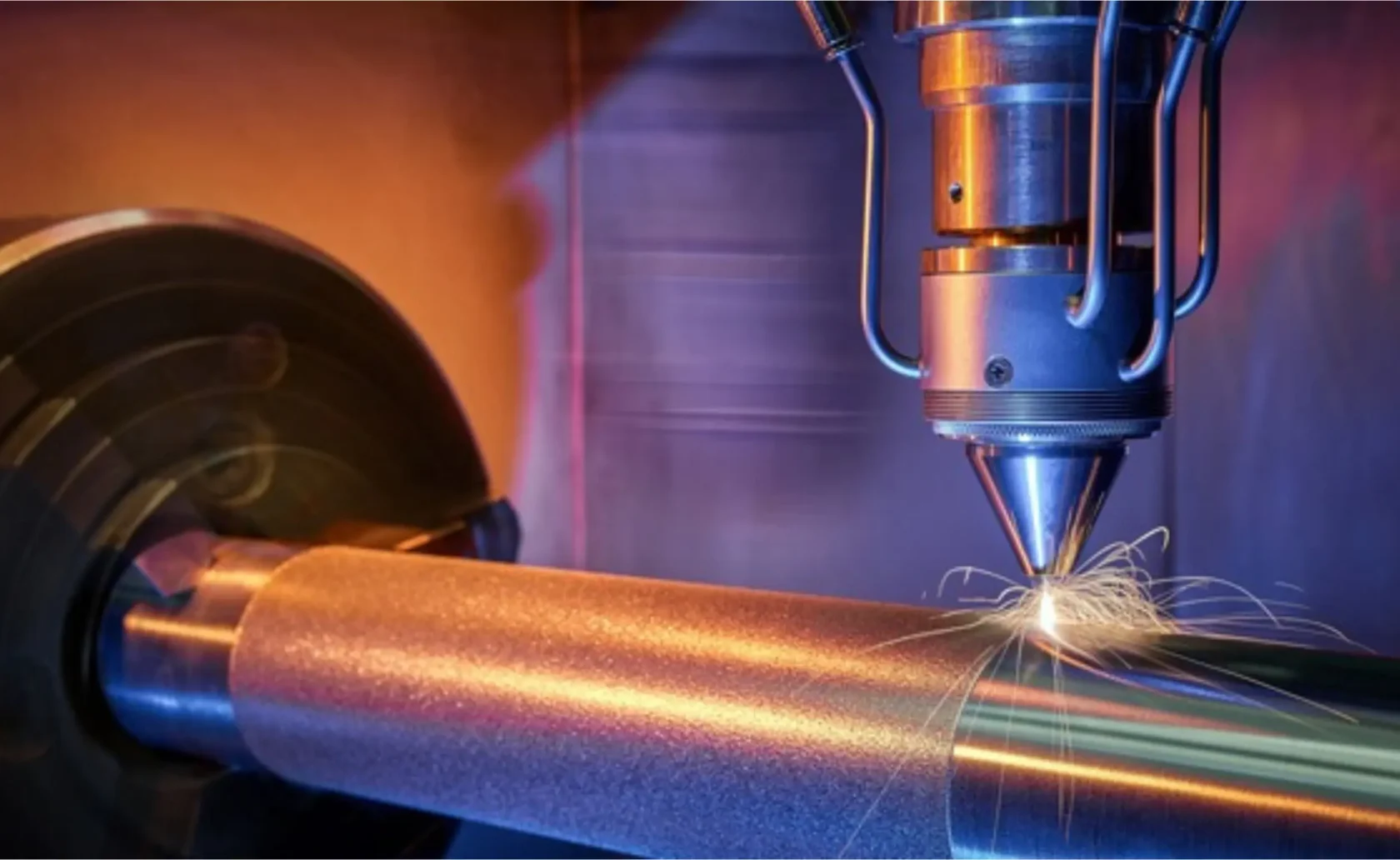 Close-up of a precision laser machine processing a metal cylinder, emitting sparks.